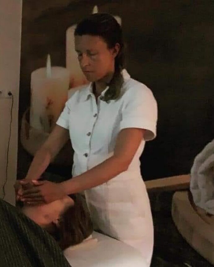 A Marta a aplicar Reiki a uma cliente deitada na marquesa do seu espaço